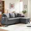 A dark gray sectional sofa with a chaise lounge is shown in a well-lit living room setting. Produktbild-Vorschau