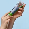 Hands holding a tube of toothpaste. Voir les images du produit