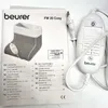 A Beurer FW 20 Cosy foot warmer is shown next to its instruction manual. Produktbild-Vorschau