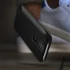 A black smartphone case is shown in a close-up shot, with a white sneaker in the background. Anteprima dell’immagine prodotto