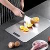 A person is cutting oranges on a stainless steel cutting board, with meat and mushrooms nearby. Produktbild-Vorschau