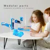 Two children are assembling a blue 3D printer on a white table. Produktbild-Vorschau