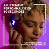 A close-up of a person's ear with a glowing earbud, set against a vibrant purple and pink gradient background. Voir les images du produit