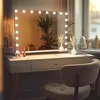 A vanity mirror with LED lights on a dressing table, with decorative vases and makeup products. Produktbild-Vorschau