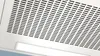 A close-up view of a kitchen range hood with a perforated metal surface and an integrated LED light. Voir les images du produit