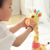 Gelbes Plüsch-Giraffenspielzeug mit orangefarbenen Flecken und einem rosa Tupfentuch, von einem Kind gehalten Podgląd zdjęcia produktu