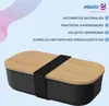 A black lunchbox with a wood-grain lid secured by a black elastic band, set against a light blue background with abstract wavy lines. Produktbild-Vorschau