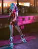 A woman dressed as Harley Quinn poses in front of a train car. Produktbild-Vorschau