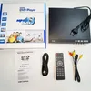 A DVD player and its accessories are laid out on a white surface, with the product box in the background. Náhled obrázku produktu
