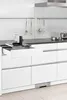 A modern kitchen with white cabinets and a pull-out drawer containing a food slicer. Podgląd zdjęcia produktu