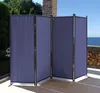 A blue fabric room divider is set up on a patio with a view of the ocean. Produktbild-Vorschau