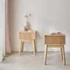 Two wooden nightstands with drawers are placed in a room with a curtain and a wall. Produktbild-Vorschau