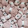 A collection of pastel pink macrame cords, neatly bundled and stacked. Produktbild-Vorschau