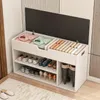 A white shoe cabinet with a hinged lid, open to reveal storage compartments for folded clothes and shoes. The cabinet has multiple shelves for shoes and a section for boots. Produktbild-Vorschau