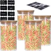 Four glass storage jars filled with colorful cereal or candy, with bamboo lids, and a set of chalk labels in the background. Produktbild-Vorschau