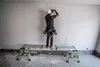 A construction worker is standing on a platform, working on a wall. Produktbild-Vorschau