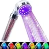 A close-up of a shower head with purple LED lights and water spraying out. Produktbild-Vorschau