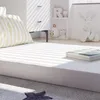 A child's mattress with a striped pillow is shown in a bright, sunlit room. Voir les images du produit