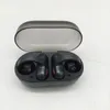 A pair of black wireless earbuds in an open charging case, placed on a white surface. Voir les images du produit