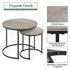 A set of two round nesting tables with a gray wood-grain top and black metal legs, shown with close-up details of the materials and construction. Produktbild-Vorschau