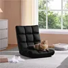 A black floor chair with a cat on it, placed in a room with a dresser and a window.