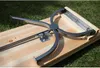 Close-up of the underside of a wooden bench with its metal folding leg mechanism. Náhled obrázku produktu