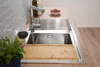 A kitchen sink area with a faucet, cutting board, and some greenery. Produktbild-Vorschau