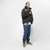A man stands against a white background wearing a black puffer jacket. Voir les images du produit