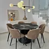 A dining table with chairs and a modern chandelier. Produktbild-Vorschau