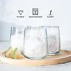 Three clear, ribbed glasses filled with ice are arranged on a wooden tray with lemon slices. Produktbild-Vorschau