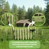 A wooden fence in a grassy field with a small cabin in the background. Produktbild-Vorschau