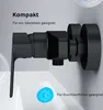 A black shower faucet is mounted on a light gray wall, with a white sink in the foreground. Produktbild-Vorschau