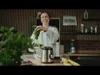 A woman is preparing ingredients for a smoothie in a kitchen. Produktbild-Vorschau