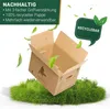 A cardboard box is shown tilted on a patch of grass, with green leaves floating around it. Produktbild-Vorschau