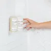 A hand is shown reaching for two Olaplex bottles in a shower. Podgląd zdjęcia produktu
