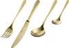 A set of gold-colored cutlery, including a fork, knife, and two spoons, arranged diagonally on a white background. Anteprima dell’immagine prodotto