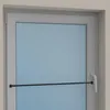A close-up view of a white window frame with a blue glass pane and a black tension rod attached horizontally across it. Produktbild-Vorschau