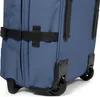 Close-up view of the bottom section of a blue rolling suitcase, showing the wheels and straps. Náhľad obrázku produktu