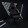 A gaming chair is displayed in a dark room with neon lights. Produktbild-Vorschau