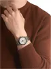 A close-up shot of a person's wrist wearing a silver watch. Produktbild-Vorschau