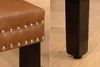 A close-up view of a chair's upholstered seat and one of its legs. Produktbild-Vorschau