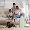 A family and their dog are relaxing in a living room with an air purifier and diffuser. Produktbild-Vorschau