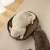 Two cats are interacting with a cat bed that has a scratching surface. Produktbild-Vorschau