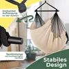 A close-up view of a beige hanging chair with black ropes, suspended from a metal bar. The image highlights features like the swivel suspension and the wooden spreader bar, with text overlays in German. Produktbild-Vorschau
