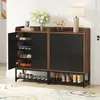 A shoe cabinet with shoes stored inside and on shelves, placed in a hallway with a rug and a lamp. Anteprima dell’immagine prodotto