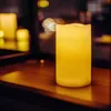 A close-up of a flameless LED candle on a wooden surface, with blurred lights in the background. Náhled obrázku produktu