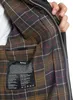 Close-up view of the inside lining of a jacket, showing a plaid pattern and a care label. Produktbild-Vorschau