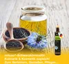 A still life arrangement of black cumin seeds, black cumin oil in a jar and a bottle, and a black cumin flower on a wooden surface. Produktbild-Vorschau