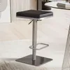 A modern bar stool with a black seat and a silver metal base and stem, placed on a rug in a room. Produktbild-Vorschau