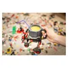 A hand holding a mug made of LEGO-compatible bricks, with a straw in it, on a floor covered in LEGO bricks. Anteprima dell’immagine prodotto